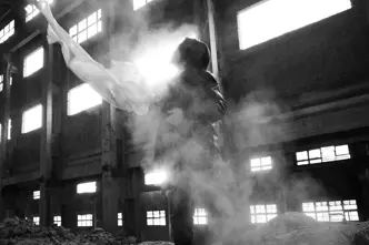 Black-and-white photograph of a man holding a white cloth in an empty old building