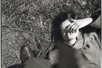 Frau liegt im im Gras und hält sich Hand ins Gesicht, Saul Leiter