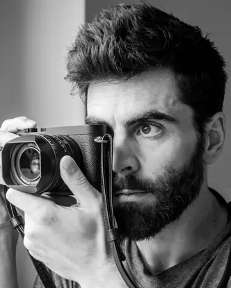 Close-up of a Philipp Weinmann taking a picture with a Leica camera.