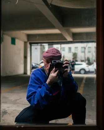 A man takes a picture of himself in a mirror in a garage.