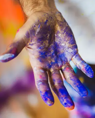 Close-up of hands smeared with blue paint.