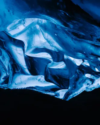 A glowing blue ice formation in a dark cave.
