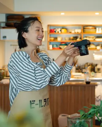 Smiling woman taking a picture of a plant in a food store.