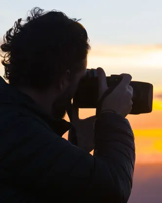 A photographer takes a photo of the sunset.