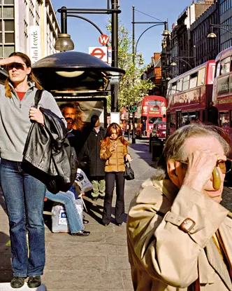 A woman who was standing on a bench, appearing to be looking for something and other people