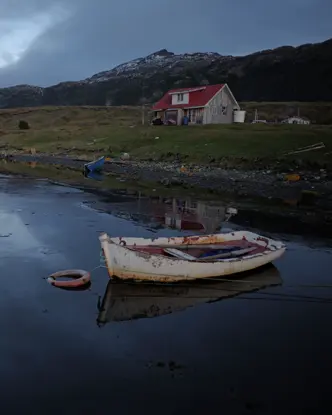 lonely house by the lake with an old boat
