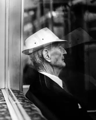 Reflection of an old man sitting in the subway