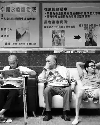 people sitting on bench at bus stop blakc and white
