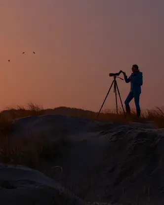 Woman is digiscoping in the sunrise
