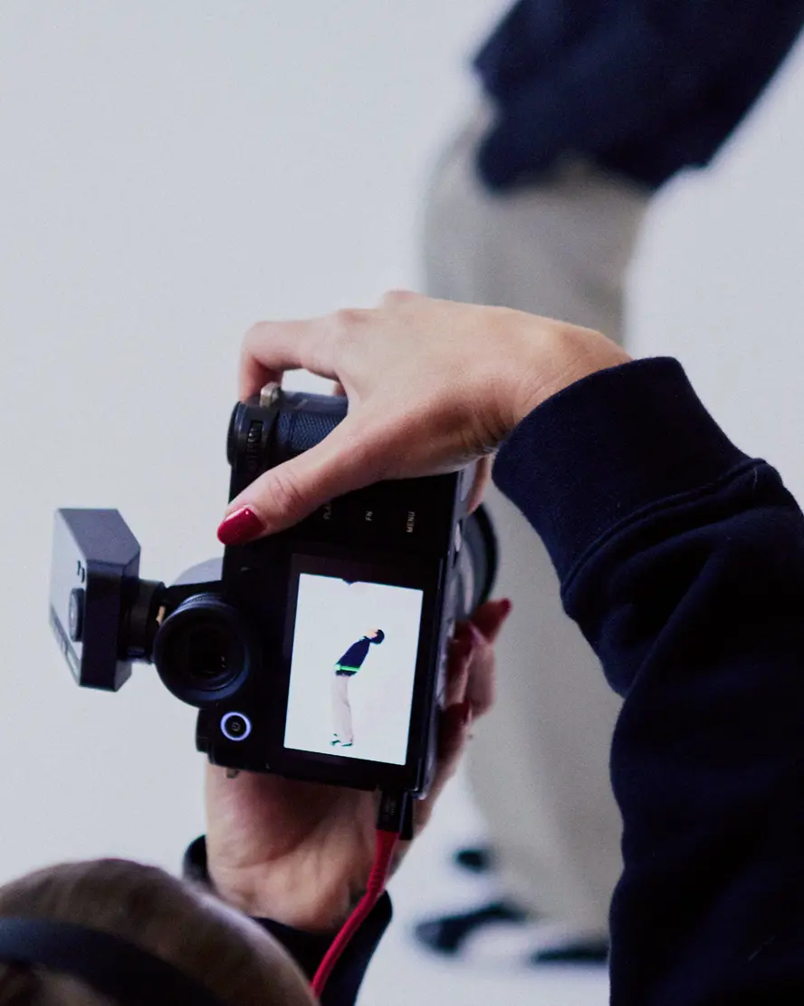 Photographer from behind in a photo studio photographing a man