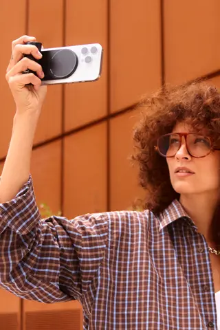Woman with curly hair using the Leica LUX Grip