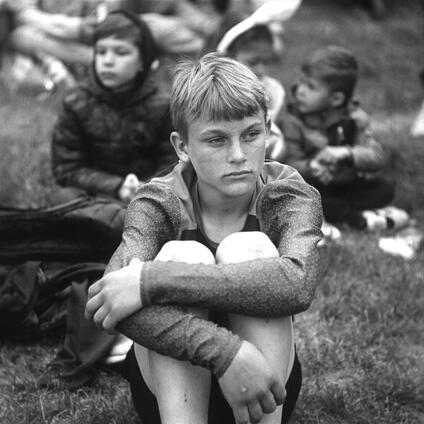 Boys sitting in the grass.