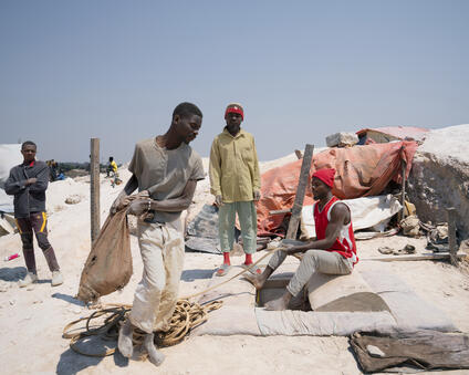 People carrying bags full of minerals.