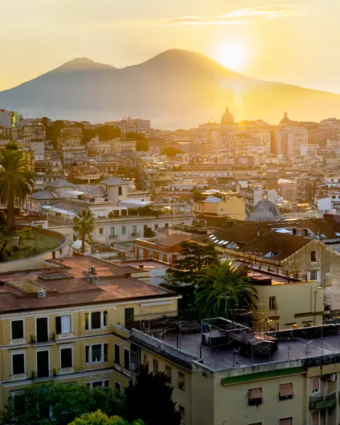 Italian city and the sun setting behind a mountain.