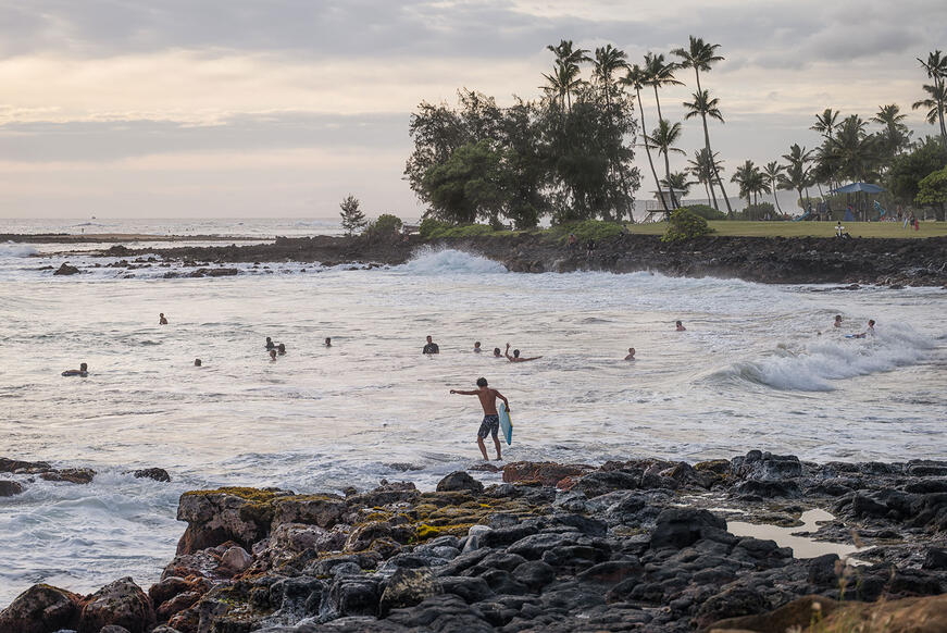 Surfers in Hawaii are enjoying the sunset