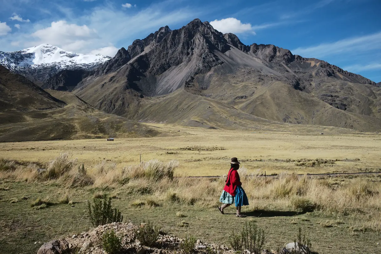 A person walking with a mountain in the background