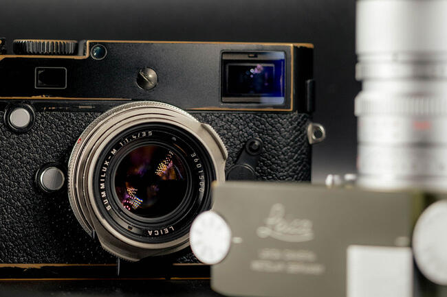 A close up of a pre-owned Leica M2 with a Safari Green M in front.